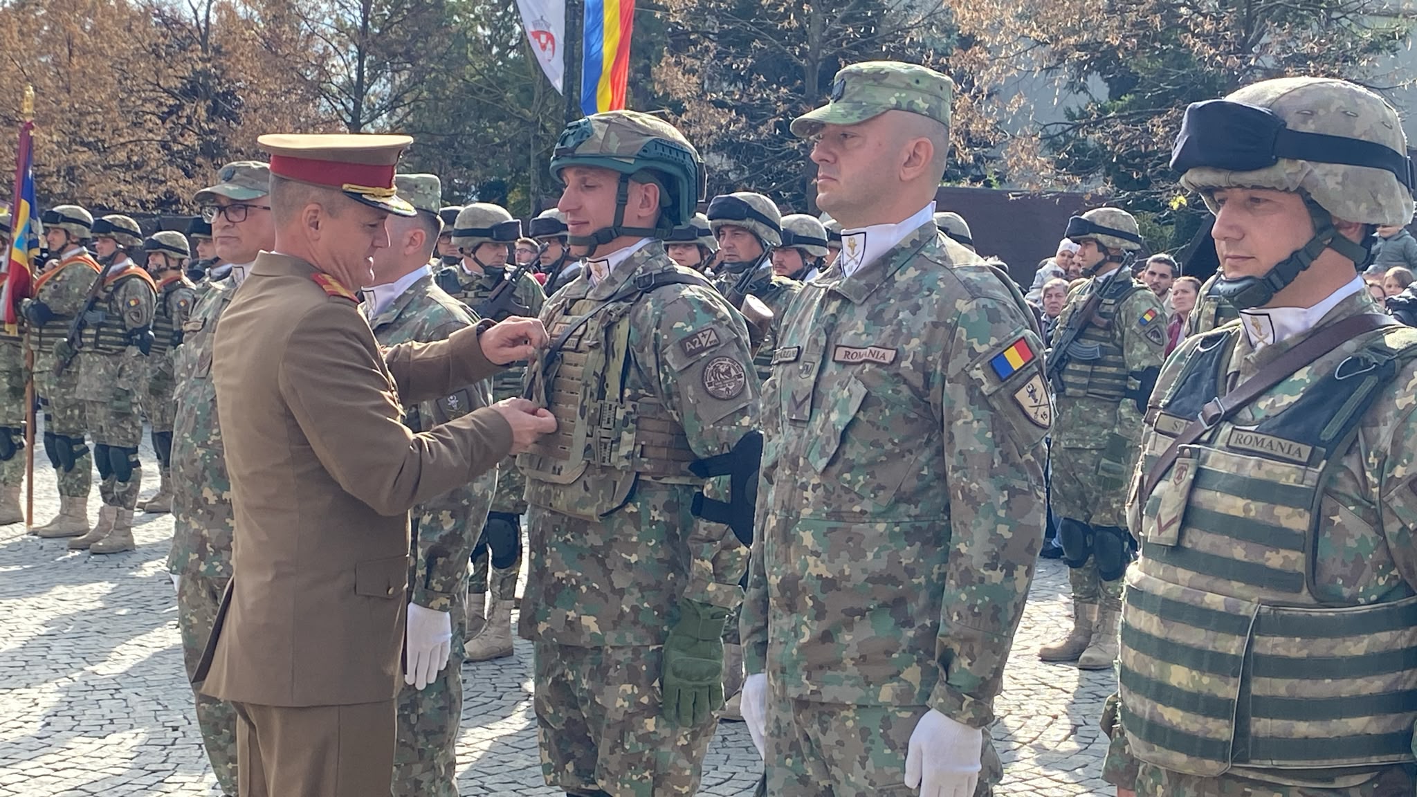 Ofițer superior înmânând distincții militarilor aliniați în formație, la ceremonia de Ziua Armatei de la Iași
